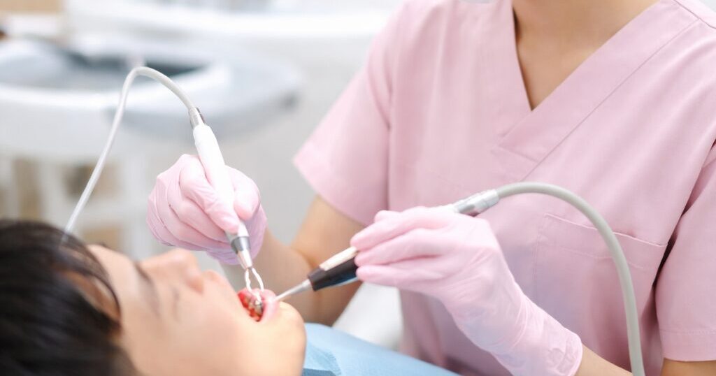 日本牙科诊所中的齿科卫生士为患者进行洁牙治疗